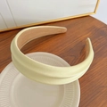 Elegant wide pale yellow satin headband displayed on a minimalist white ceramic plate - Cream Yellow Sponge Headband