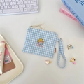 Macro detail of blue checkered canvas storage pouch with house embroidery and strap - House
