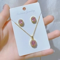 Close-up of gold necklace and earring set with pink oval stones on soft silk fabric - Gold Pink Stone Set (R)