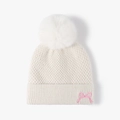 Cremefarbene Strickmütze mit weißem Bommel und rosa Schleifenstickerei für Winter - Gebrochenes Weiß
