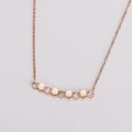 Dettaglio del ciondolo a nido d'ape in oro rosa con cinque pietre di zircone lucide - Oro rosa