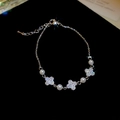 Macro shot of silver-tone clover bracelet with sparkling zircons and white round pearls - Silver (Real Gold Plating)