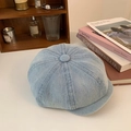 Detail shot of light blue denim newsboy cap on a desk with vintage books and accessories - Light Blue Short Brim Newsboy Hat