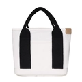 Detail of white canvas tote bag with black handles and a khaki leather side label - Black and White Patchwork
