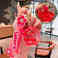 Pink sakura rose liquid glitter oil keychain with a cute floral doll and gold clip - Lanyard Style / Red