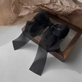 Elegant large black chiffon bow hair clip displayed on a rustic wooden frame background - Black Spring Clip