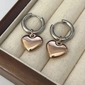 Dettaglio macro di orecchini a cerchio bicolore con ciondolo a cuore lucido a specchio - Cerchio Argento + Cuore Oro Rosa