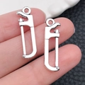 Miniature silver saw pendant charms made of alloy metal, set of two pieces - 7x26mm 1.2g