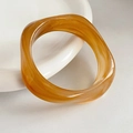 Dettaglio di un bracciale spesso in resina ambrata con trama marmorizzata sul piatto - Bracciale Ambra Caffè