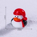 Miniature Christmas penguin figurine with red hat and scarf standing on snow background - Red Hat Christmas Duck