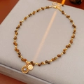 Dettaglio della collana con occhio di tigre con chiusura a moschettone oro e ciondoli tondi - Caffè (Placcato in oro reale)