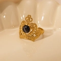 Detailed close-up of golden crown ring with grey cat eye stone on ceramic background - Black Gem-Gold