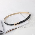 Flat lay of a slim black leather belt with a golden rectangular buckle on a magazine - Black