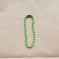 Detail of 2.4mm green painted bead chain with connector on brown kraft paper - Emerald Green