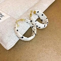 Dettaglio degli orecchini a cerchio in tessuto a pois neri con ganci in metallo oro - Bianco