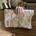 Floral embroidered brocade makeup bag with A GOGO ORIGINAL label held in hand - Full Blossom Floral