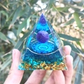 Handheld crystal pyramid with blue sphere and gold leaf layering in natural light - 80 / 5cm