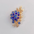 Elegant gold flower brooch with gradient blue rhinestones and textured metal leaves - Blue Gradient Flower