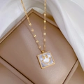 Close-up of gold square necklace featuring a white shell inlay and happy smiley face detail - Gold