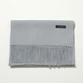 Detail shot of a light gray cashmere scarf with a premium tassel fringe and brand label - 70cm / Medium Grey