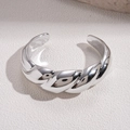 Macro-opname van een zilveren gedraaide armband met een glanzende textuur - Gedraaid Touw Stijl / Zilver