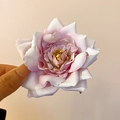 Primer plano de una pinza para el pelo con rosa de tela rosa mostrando texturas de pétalos - Clip de pico de pato con flor de rosa rosa blanco