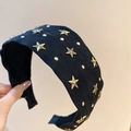 Détail du serre-tête en tissu noir avec rivets étoiles dorés et design large antidérapant - Noir