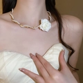 Elegant gold chain necklace with white fabric rose and pearls on model neck - Gold White