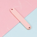 Detail eines roségoldenen rechteckigen Metallanhängers mit zwei Löchern für DIY-Schmuck - Roségold