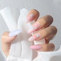 Mandelförmige Kunstnägel mit rosa und hellblauen Herzmustern auf der Hand eines Modells - Rosa Violett Herz Mandel Nägel - Kleber Stil (Y-108)