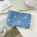 Detail der Denim-Münztasche mit Sternenprint neben Laptop und Reisezubehör - Dunkelblau