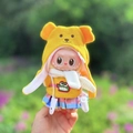 Labubu doll wearing yellow bear ear hoodie and colorful plaid skirt in a natural setting - Angry Crocodile / First And Second Generation Keychains Are Compatible With La Cloth Dolls. Dolls Not Included.