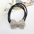 Dettaglio dell'elastico nero con un fiocco dorato scintillante decorato con strass - Strass Oro