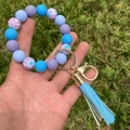 Dettaglio di bracciale in silicone con nappa di pelle azzurra e chiusura dorata - Combinazione Spirale Blu Viola (A6)