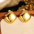 Polished gold square curved stud earrings set on a fabric display stand - Gold Square Curved Mirror Surface Earrings