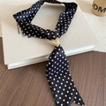 Close-up of black polka dot silk scarf with a golden heart-shaped buckle on a book - Black Polka Dot (Heart Buckle)