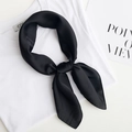 Minimalist black satin square silk scarf tied in a bow on a white shirt background - Black