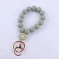 Detailed macro view of daisy silicone beaded keychain with rose gold lobster clasp - Green