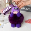 Detail of a purple fox fur baby doll keychain with a knit hat and LOVE ribbon strap - Purple