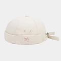 Close-up of pink lit embroidery on a beige canvas docker hat with adjustable strap - Beige