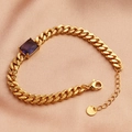Detailed close-up of a gold-plated bracelet with a purple rectangular zircon on pink satin - 18K Gold / Purple Zircon
