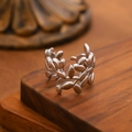 Adjustable silver leaf open ring with olive branch design on a wooden pedestal - Olive Branch Wrap / Steel