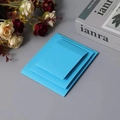 Blue PE film jewelry suspension boxes in three sizes stacked on a grey background - Blue Cardboard Sleeve / Round Base