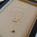 Detalle de collar con colgante de calabaza dorada y cuenta ojo de tigre en cadena serpiente - Collar - Dorado