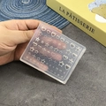 Transparent silicone nail mold for DIY 3D bow and star shapes, shown held over a grey surface - 103-Heart Star