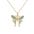 Macro detail of gold butterfly necklace with teal and pink enamel and zircon accents - Blue-Green & Light Pink