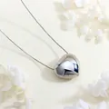 Detailed view of a silver 3D heart pendant on a box chain with floral background - Silver Large 3D Heart