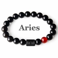 Macro view of Aries beaded bracelet featuring polished black beads and a red accent bead - Aries
