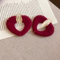 Close-up of heart-shaped earrings with burgundy wool wrap and gold bead trim on book pages - Burgundy Thread-Wrapped Heart Metal Earrings (24# Silver Earring Post - Rose Red)