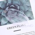 Leaf shaped transparent banana hair clip with dense teeth on a green plant background - 14cm Transparent